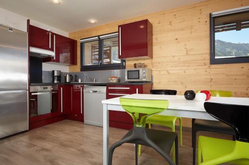 a kitchen with a refrigerator, microwave, sink, and dishwasher at Appartements de l'Hôtel de l'Arve in Chamonix-Mont-Blanc