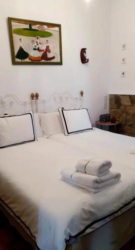 a bedroom with a white bed with towels on it at CANTO DA AREA in Fisterra