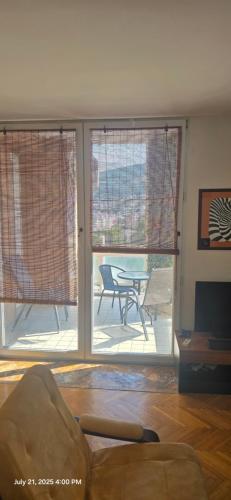 a living room with two large windows and a table at Risto Apartment in Skopje