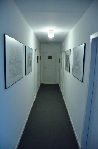 a hallway with framed pictures on the walls at Willa Uroboros in Szklarska Poręba