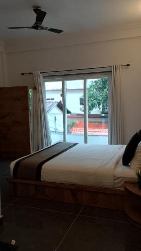 a bedroom with a bed and a large window at Rankk Stays in Arambol