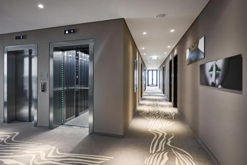 a hallway of a building with lights on the floor at LÉGÈRE HOTEL Bielefeld in Bielefeld