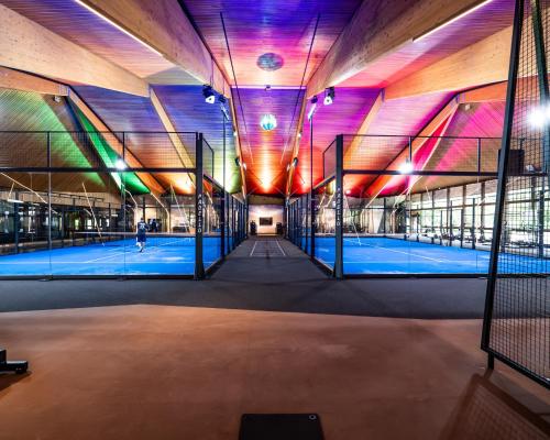 an indoor tennis court in a building with colorful lights at Hotel Vier Jahreszeiten am Schluchsee in Schluchsee