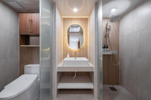 a bathroom with a sink and a toilet and a mirror at Gridt Hotel & Home in Gyeongju