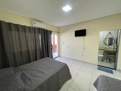 a bedroom with a bed and a television in it at Pousada Império in Chapada dos Guimarães