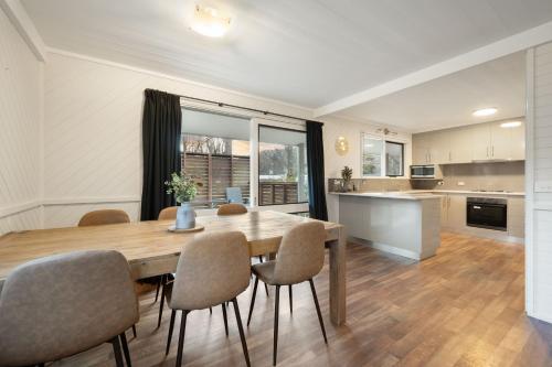 a kitchen and dining room with a wooden table and chairs at Bright Valley Holiday Park in Bright