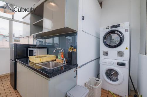 a kitchen with a sink and a washing machine at Cubicity Walking Street in Ho Chi Minh City