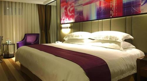 a bedroom with a large bed and a purple chair at GreenTree Inn Fujian Fuzhou Software Park River View Business Hotel in Fuzhou