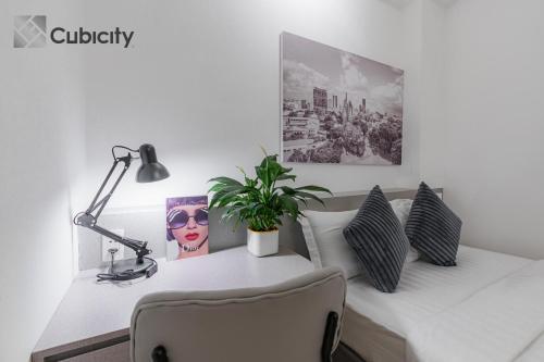 a white desk with a lamp and a plant on it at Cubicity Walking Street in Ho Chi Minh City