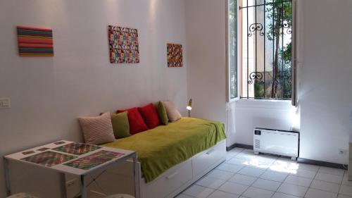 a small bedroom with a green bed with a window at Studio dans la Villa "Litita" à Nice in Nice