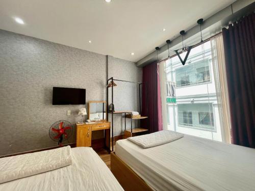 a hotel room with two beds and a window at Winny Hotel in Can Tho