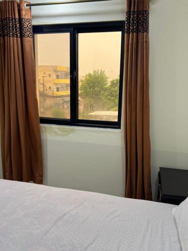 a bedroom with a bed and a window at Hotel Lavish Inn in Islamabad