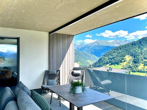a living room with a table and a view of mountains at Lynett Suites in Fliess