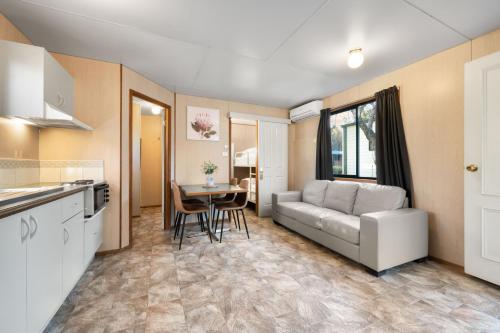 a kitchen and a living room with a couch and a table at Bright Valley Holiday Park in Bright