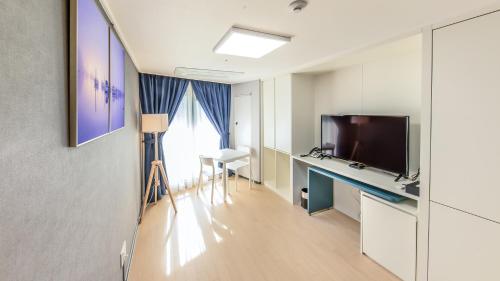 a room with a tv and a desk with a television at Risen Ocean Park Hotel in Sokcho