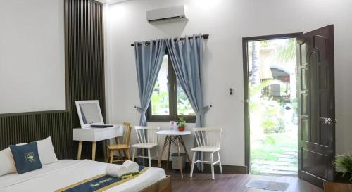 a bedroom with a bed and a desk and a table at HON BA LAGI BEACH RESORT in La Gi