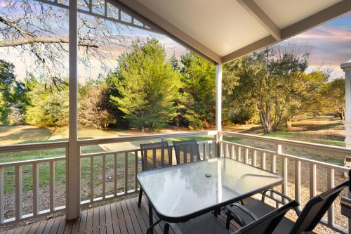 a screened porch with a glass table and chairs at Bright Valley Holiday Park in Bright