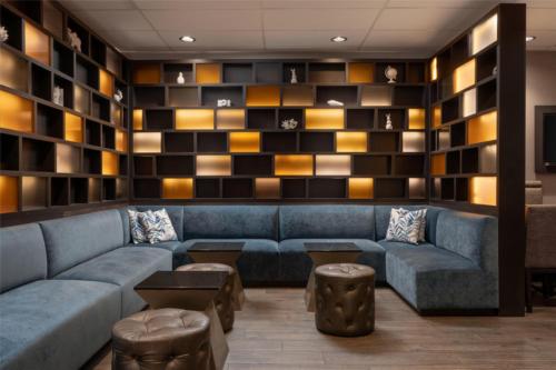 a living room with a blue couch and shelves at DoubleTree by Hilton Hotel Deerfield Beach Boca Raton in Deerfield Beach