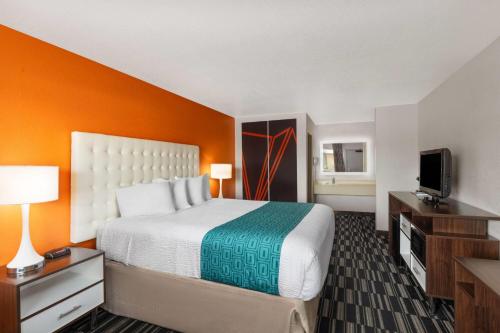 a hotel room with a bed and a flat screen tv at Howard Johnson by Wyndham Modesto Ceres in Ceres