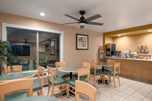 a restaurant with tables and chairs and a counter at Howard Johnson by Wyndham Modesto Ceres in Ceres