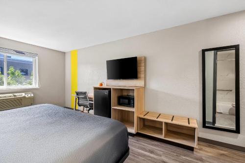 a hotel room with a bed and a flat screen tv at Super 8 by Wyndham Lewiston Auburn Area in Lewiston