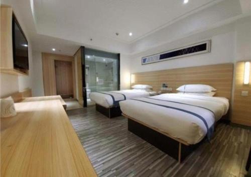 a hotel room with two beds and a television at City Comfort Inn Zhaoqing Qixingyan Scenic Area Xinghu Archway in Zhaoqing