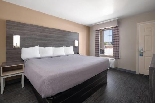 a bedroom with a large bed and a window at Baymont by Wyndham Commerce GA Near Tanger Outlets Mall in Commerce