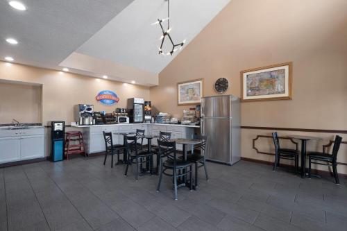 a restaurant with a bar with tables and chairs at Baymont by Wyndham Commerce GA Near Tanger Outlets Mall in Commerce