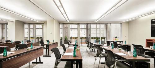 a dining room with tables and chairs and windows at Hyatt Centric Times Square New York in New York
