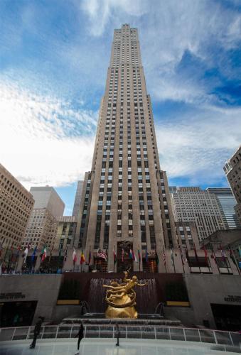 a tall building with a statue in front of it at Hyatt Centric Times Square New York in New York