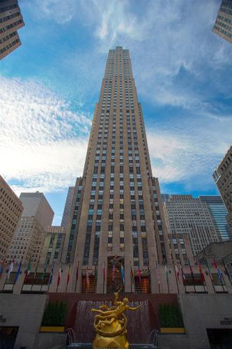 a tall building with a statue in front of it at Hyatt Centric Times Square New York in New York