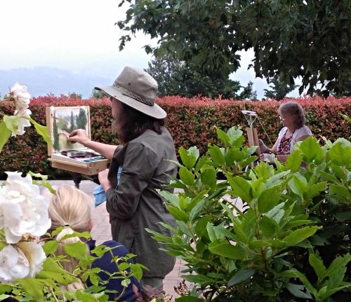 a woman in a hat holding a mirror in a garden at Residence Fiesole in Fiesole