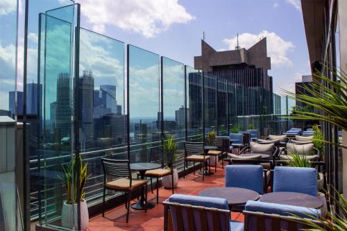 a balcony with tables and chairs and a view of the city at Hyatt Centric Times Square New York in New York