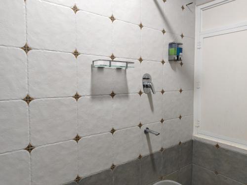 a tiled bathroom with a shower and a sink at Casa Mel in Puducherry