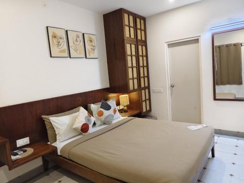 a bedroom with a large bed and a mirror at Casa Mel in Puducherry