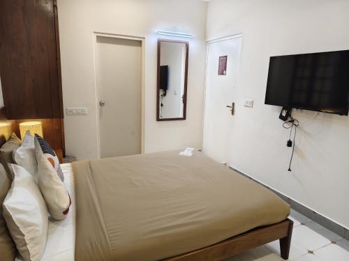 a bedroom with a bed and a flat screen tv at Casa Mel in Puducherry