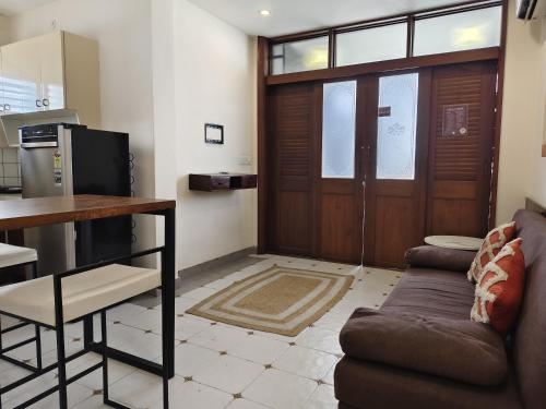 a living room with a couch and a table and a kitchen at Casa Mel in Puducherry