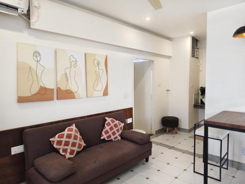a living room with a couch and paintings on the wall at Casa Mel in Puducherry