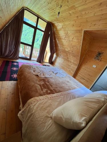 a bed in a room with a large window at Villa Belinis in Theth