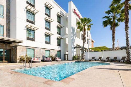 a hotel with a swimming pool in front of a building at Hampton Inn & Suites - Napa, CA in Napa