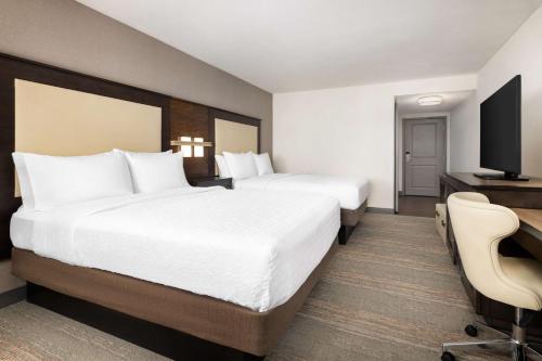 a hotel room with two beds and a flat screen tv at Hampton Inn & Suites - Napa, CA in Napa