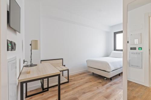 a bedroom with a bed and a desk and a bed sidx sidx sidx at Sercotel Cruz Del Mar in Chipiona