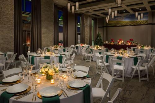 a banquet hall with white tables and chairs and a christmas tree at Hampton Inn & Suites - Napa, CA in Napa