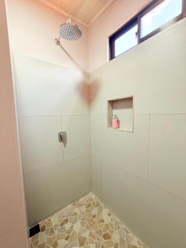 a bathroom with a shower stall with a window at Estancia Rincón Verde in Fortuna