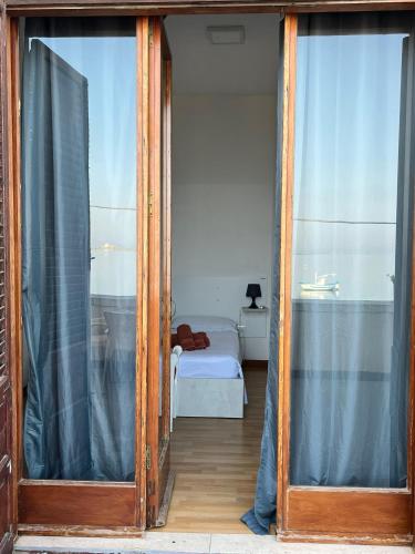 a room with two glass doors and a bed at B&B Al Vecchio Pontile Sea View in Marsala