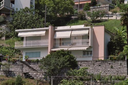 a pink house on top of a stone wall at Casa Foletta in Cugnasco