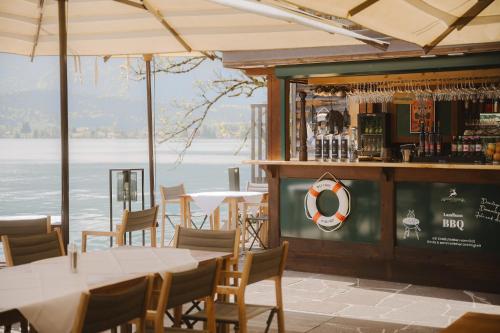 a restaurant with a bar with a view of the water at TAUROA Landhaus zu Appesbach in St. Wolfgang