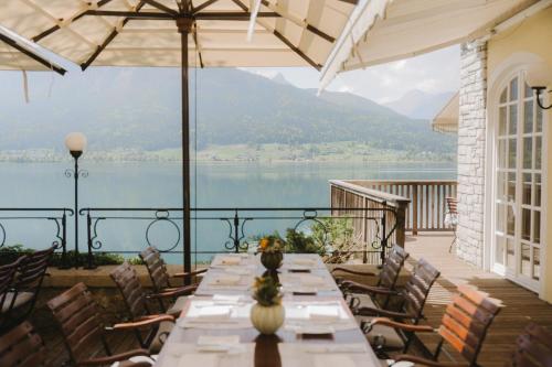 a table on a balcony with a view of a lake at TAUROA Landhaus zu Appesbach in St. Wolfgang