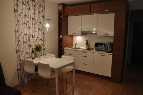a small kitchen with a white table and chairs at Apartament Motyl in Świnoujście