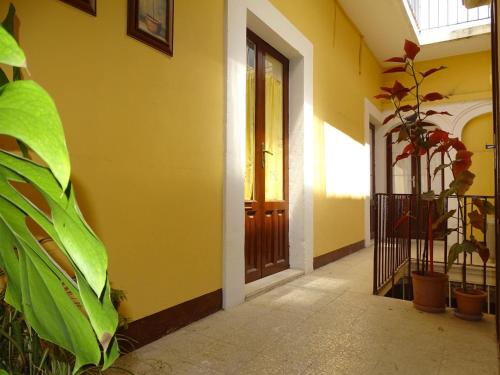a yellow building with a door and a plant at Palazzo Iargia in Canicattini Bagni